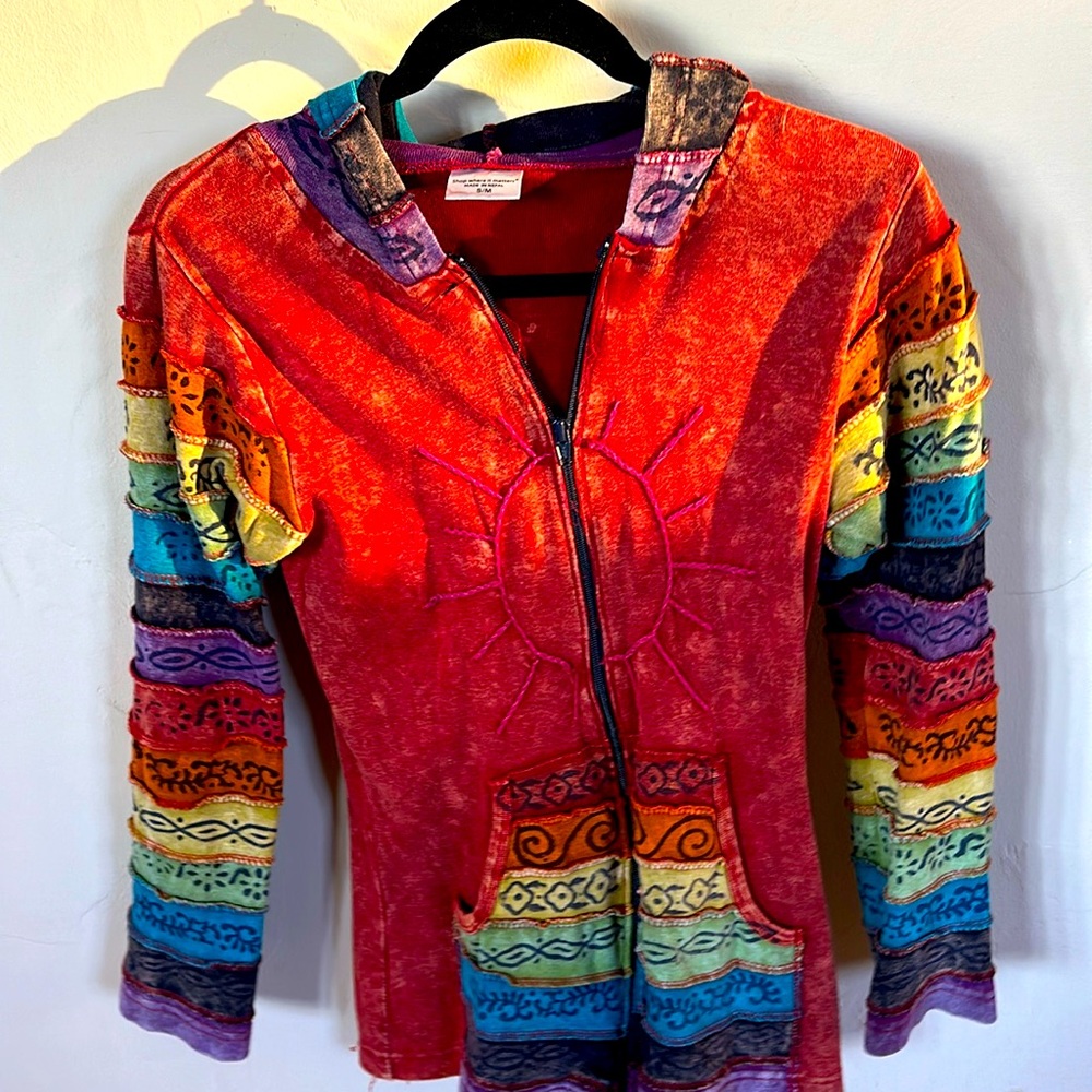 Adorable multicolored zip up jacket with pockets and hood. Made in Nepal.